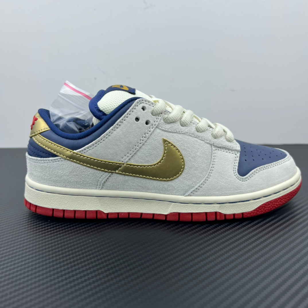 Low-top sneaker in light gray/white with gold swoosh and navy side panel, red outsole.