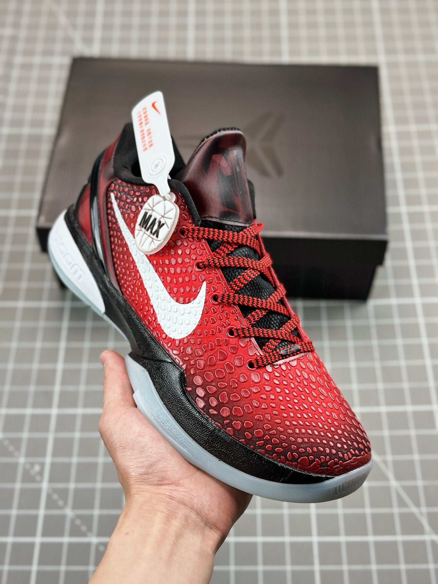 Red and black basketball shoe with white swoosh, lace-up front and speckled sole