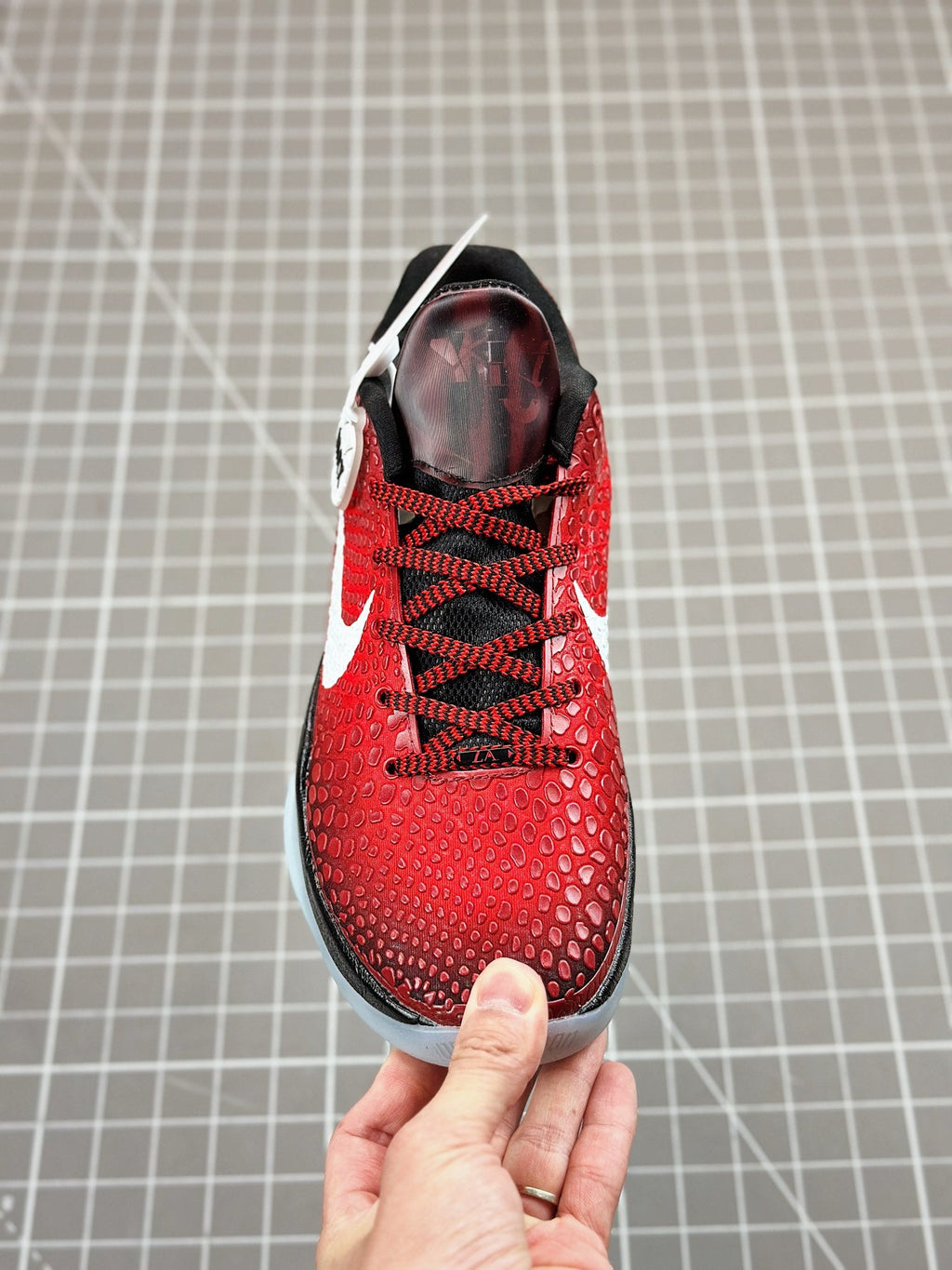 Red basketball shoe top view, black laces, white swoosh and padded collar