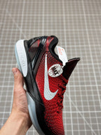 Side view of red basketball shoe with black stripes, white swoosh, and red upper