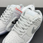 White low-top sneakers with gray swoosh detail and lace-up panels over plastic wrap.