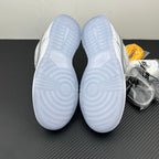 White low-top sneakers, outsole bottoms facing up with molded traction pattern.