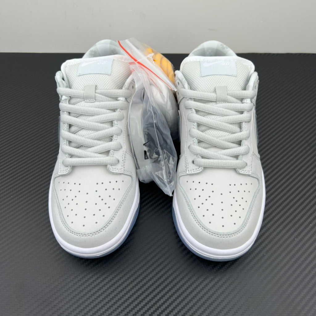 White low-top sneakers, lace-up pair shown from front with protective plastic wrap.