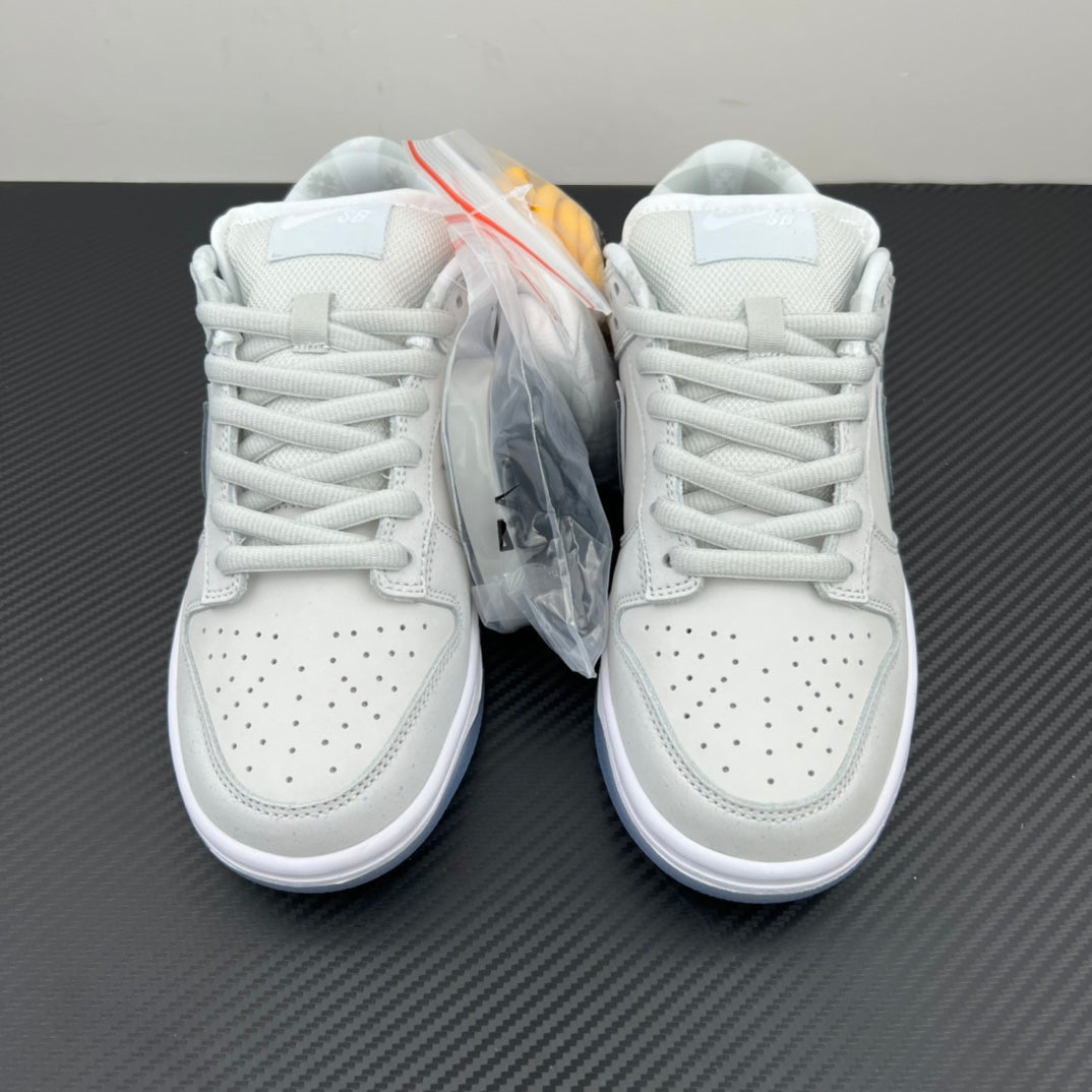 White low-top sneakers, lace-up pair shown from front with protective plastic wrap.