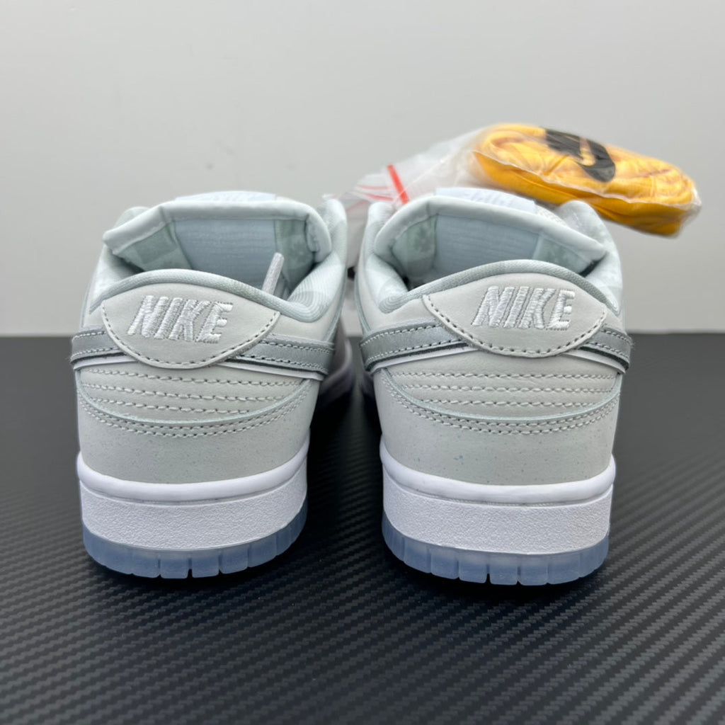 White low-top sneakers, back view with Nike logo on heel and blue outsole.