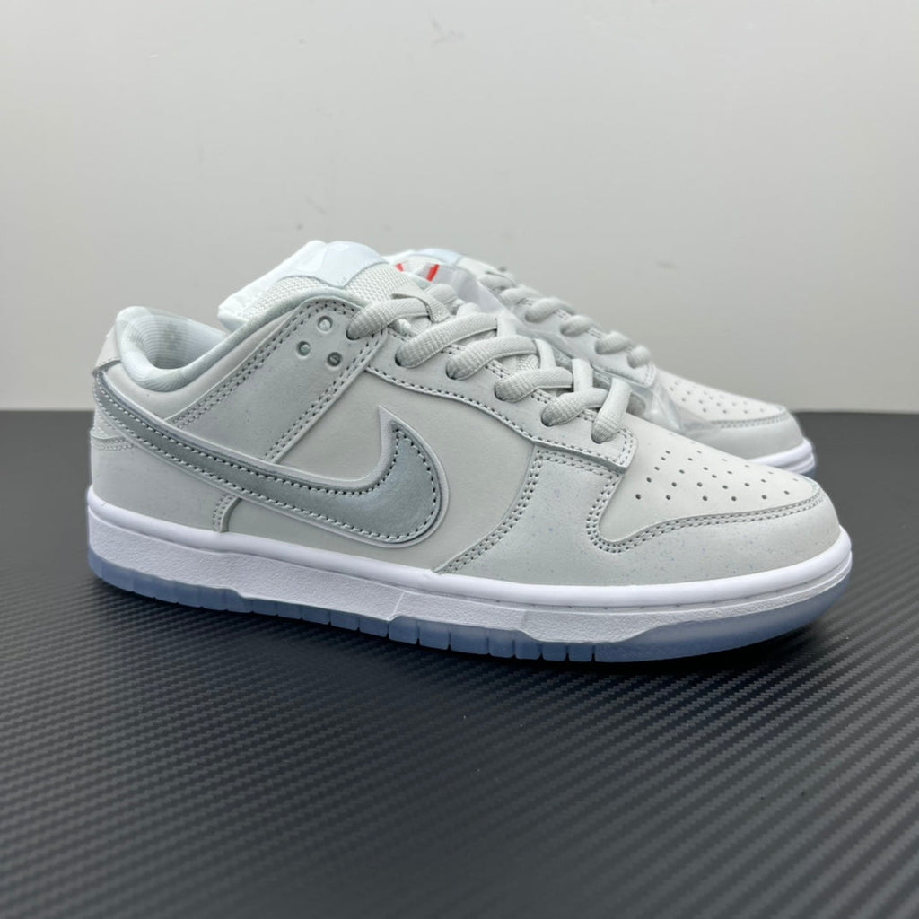 White low-top sneaker with light-gray swoosh, lace-up, blue-tinted outsole.