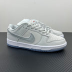 White low-top sneaker with light-gray swoosh, lace-up, blue-tinted outsole.