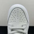 White low-top sneaker toe box close-up with perforations and lace-up front.