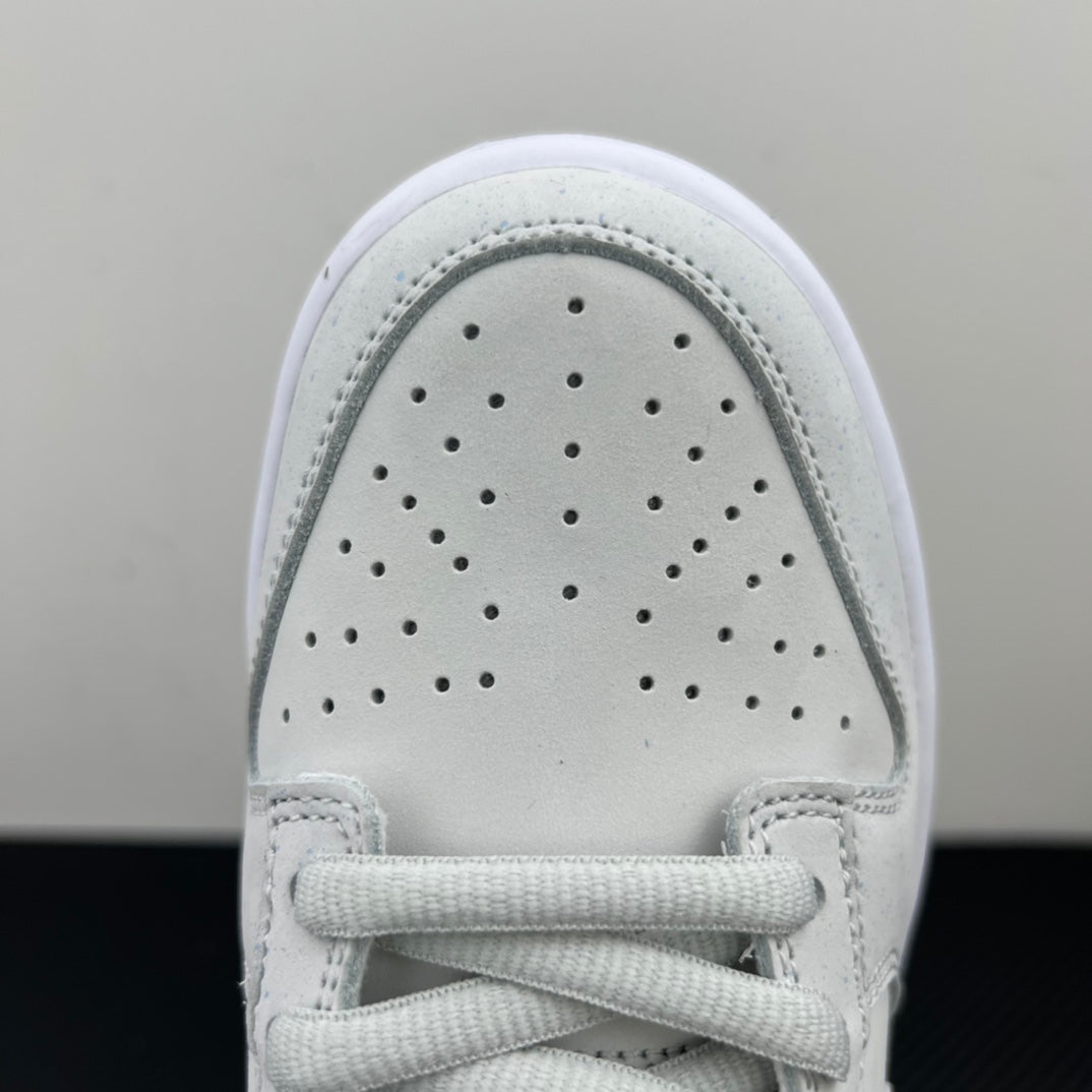 White low-top sneaker toe box close-up with perforations and lace-up front.