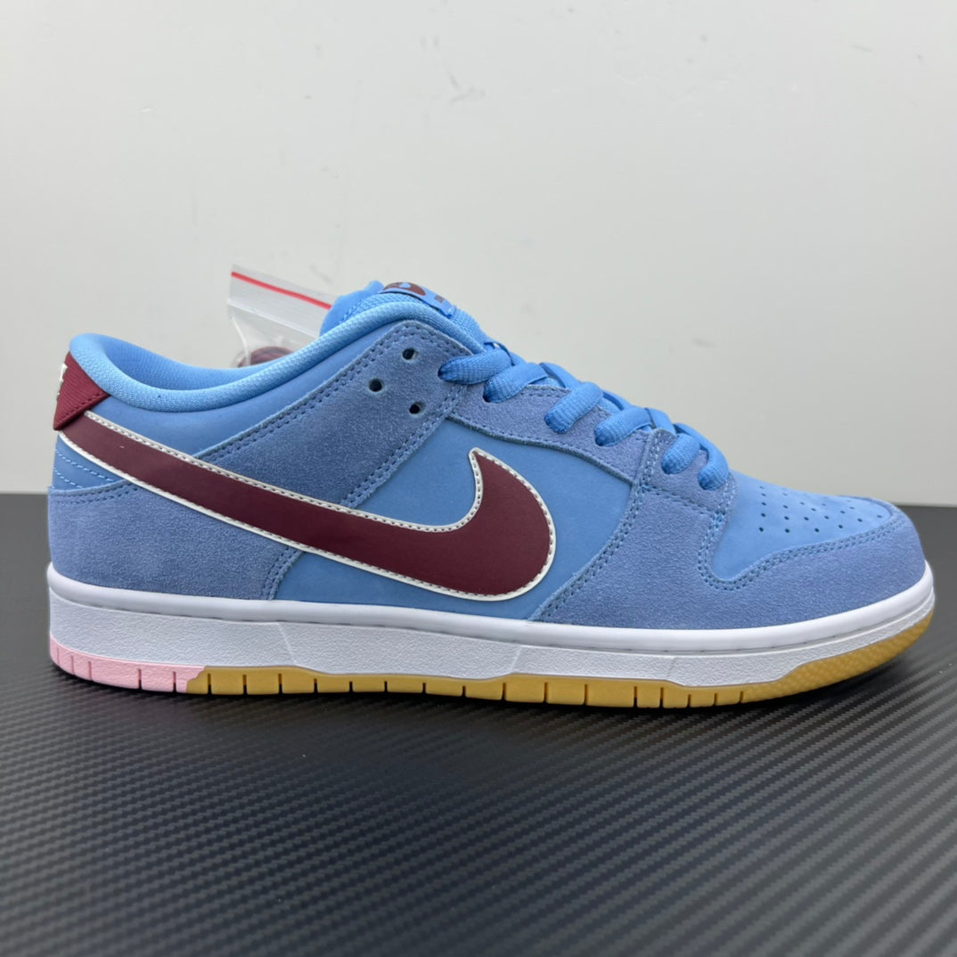 Light blue low-top sneakers with maroon Swoosh, blue laces, and white midsole