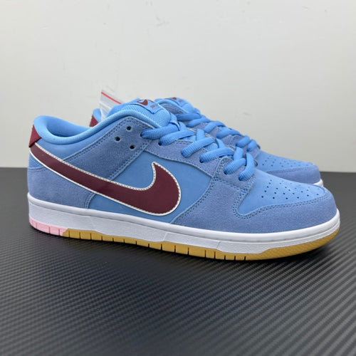 Light blue suede low-top sneakers with maroon Swoosh and white rubber sole