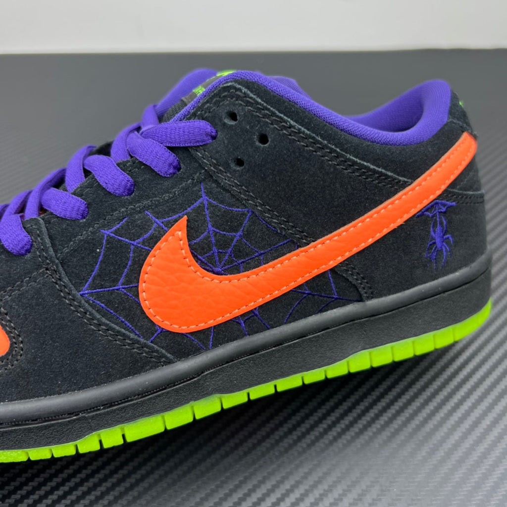 Black low-top sneaker with orange swoosh, purple laces, neon green trim and sole.