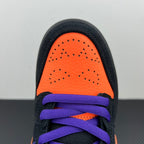 Front toe view of black sneaker with orange panel and purple laces.