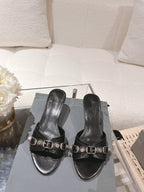 Black leather slide sandals with square-toe straps and silver buckle hardware