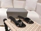 Pair of black leather slide sandals with silver buckle straps and open toe