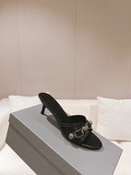 Black leather heeled slide sandals with silver buckle strap and low heel