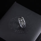 Silver-tone filigree chrome ring with a decorative oval crest and raised details.