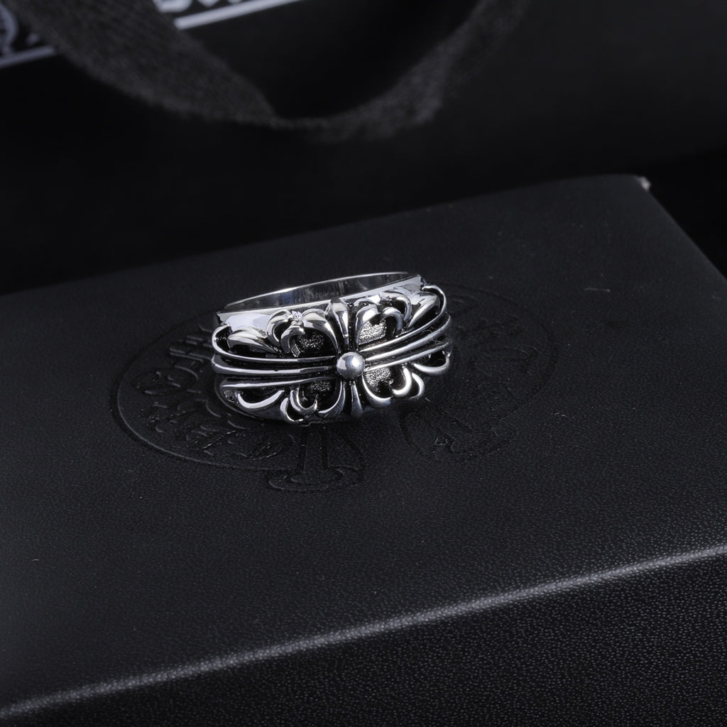 Silver-tone chrome ring with a flower-like filigree center and curved band.