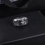 Silver-tone chrome ring with a flower-like filigree center and curved band.