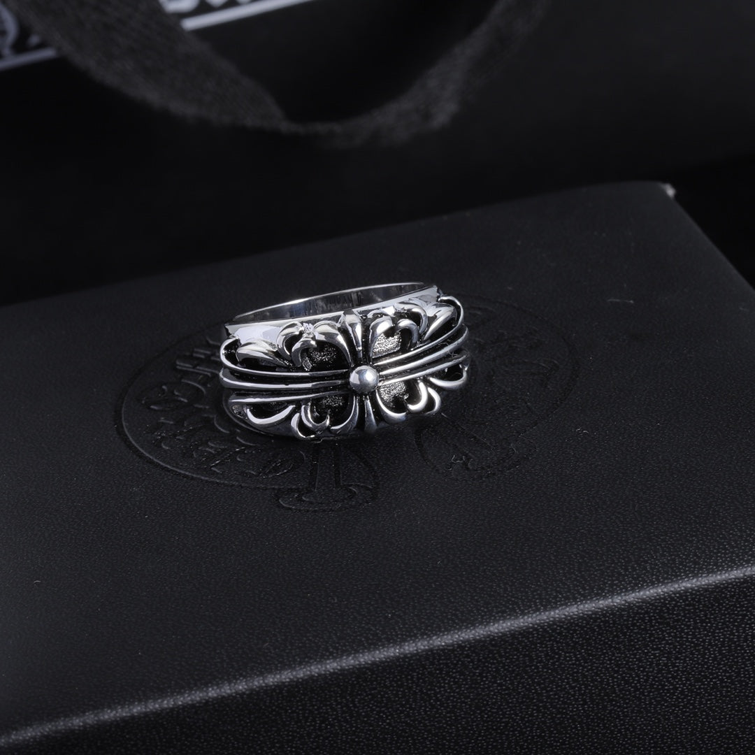 Silver-tone chrome ring with a flower-like filigree center and curved band.