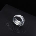 Silver-tone chrome ring shown from the side with ornate filigree detailing.