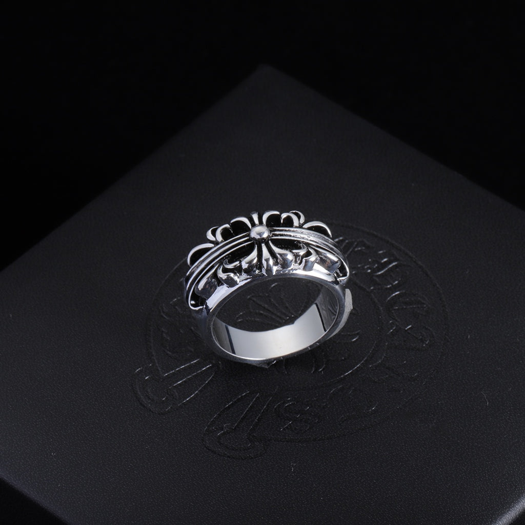 Silver-tone filigree chrome ring with central round gemstone and swirled band.