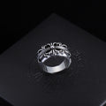 Silver-tone filigree chrome ring with central round gemstone and swirled band.