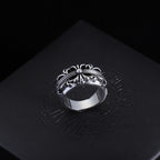 Silver-tone filigree chrome ring with central round gemstone and swirled band.