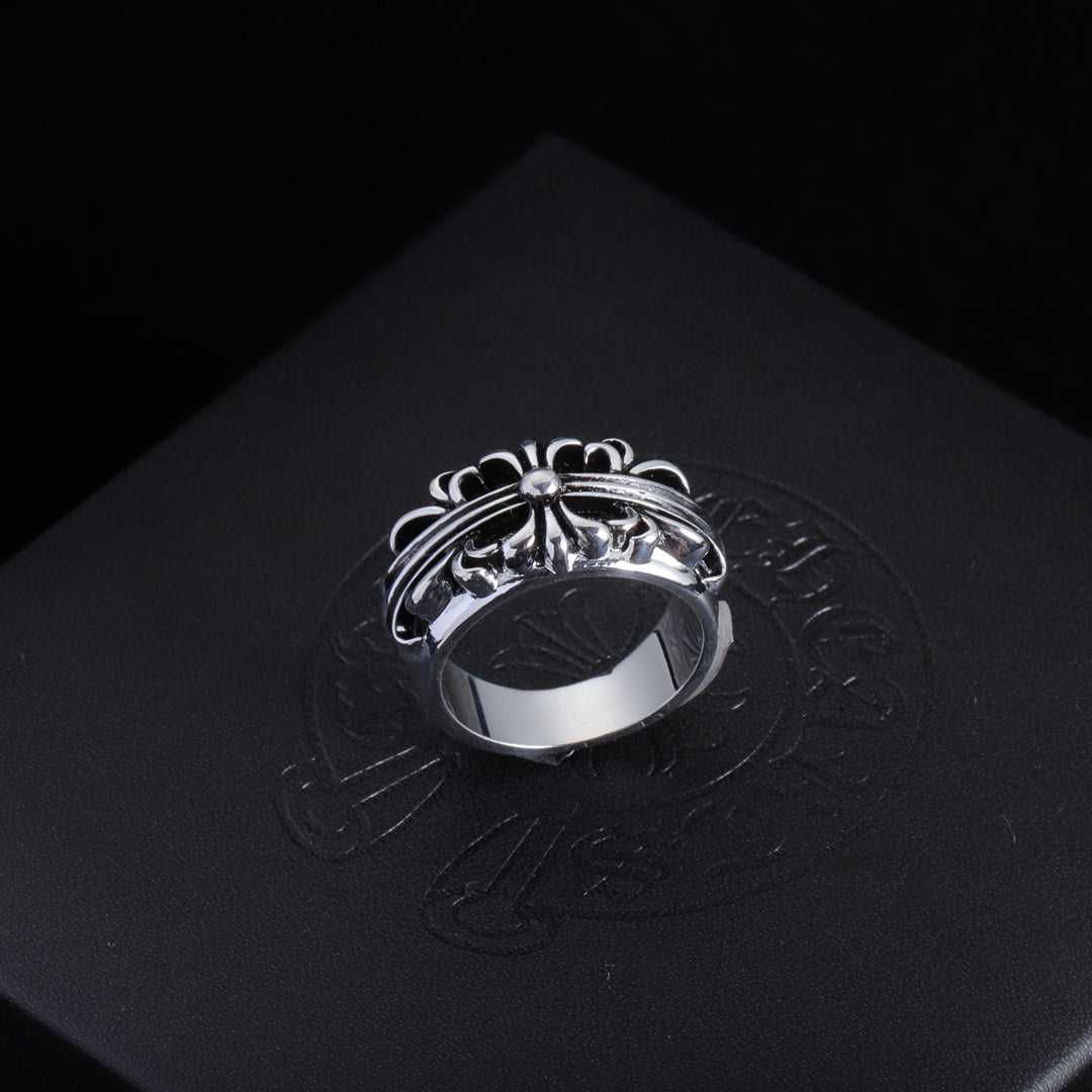 Silver-tone filigree chrome ring with central round gemstone and swirled band.