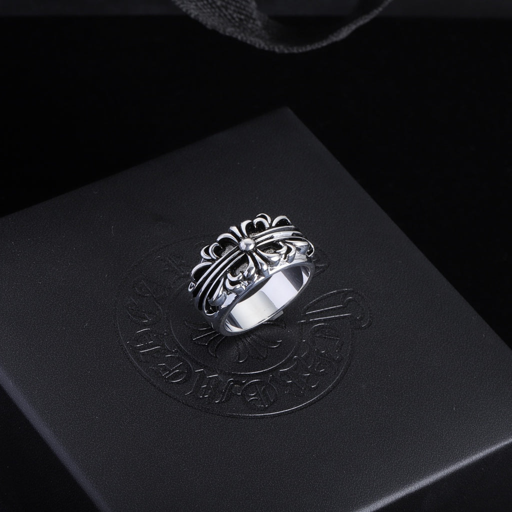 Silver-tone filigree chrome ring with central gemstone and decorative oval setting.