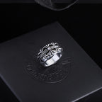Silver-tone filigree chrome ring with central gemstone and decorative oval setting.