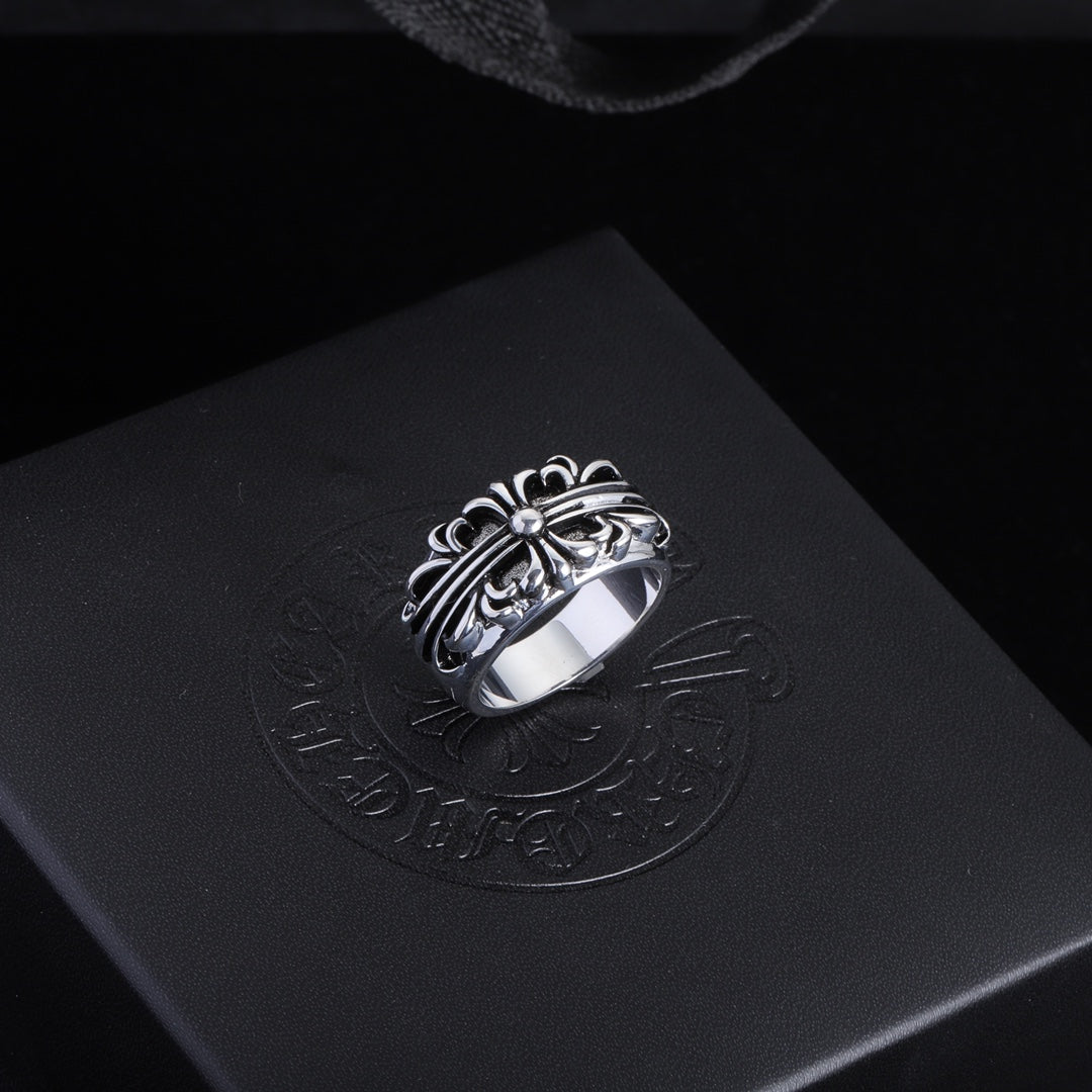 Silver-tone filigree chrome ring with central gemstone and decorative oval setting.