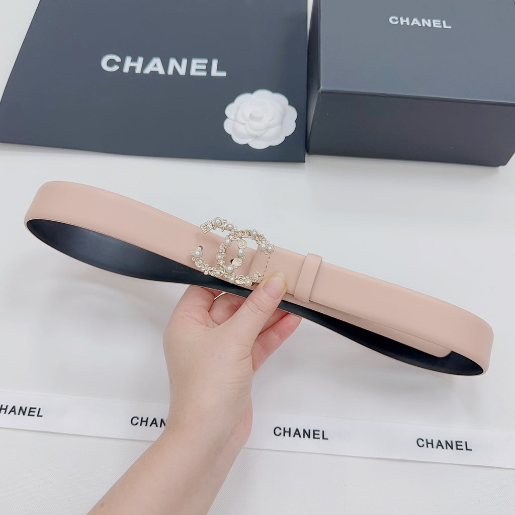 Light pink leather belt with black underside and ornate rhinestone buckle detail