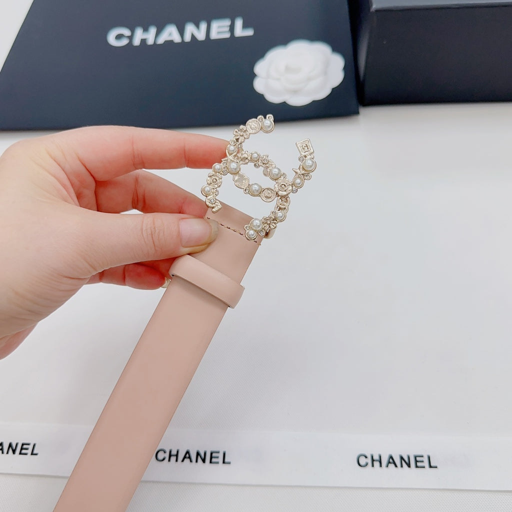 Light pink leather belt segment with ornate rhinestone buckle, held in a hand