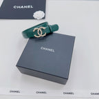 Green Chanel belt with gold and pearl buckle, folded end visible
