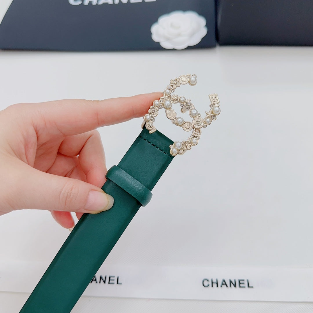 Green Chanel belt end with gold and pearl buckle decoration, held in hand