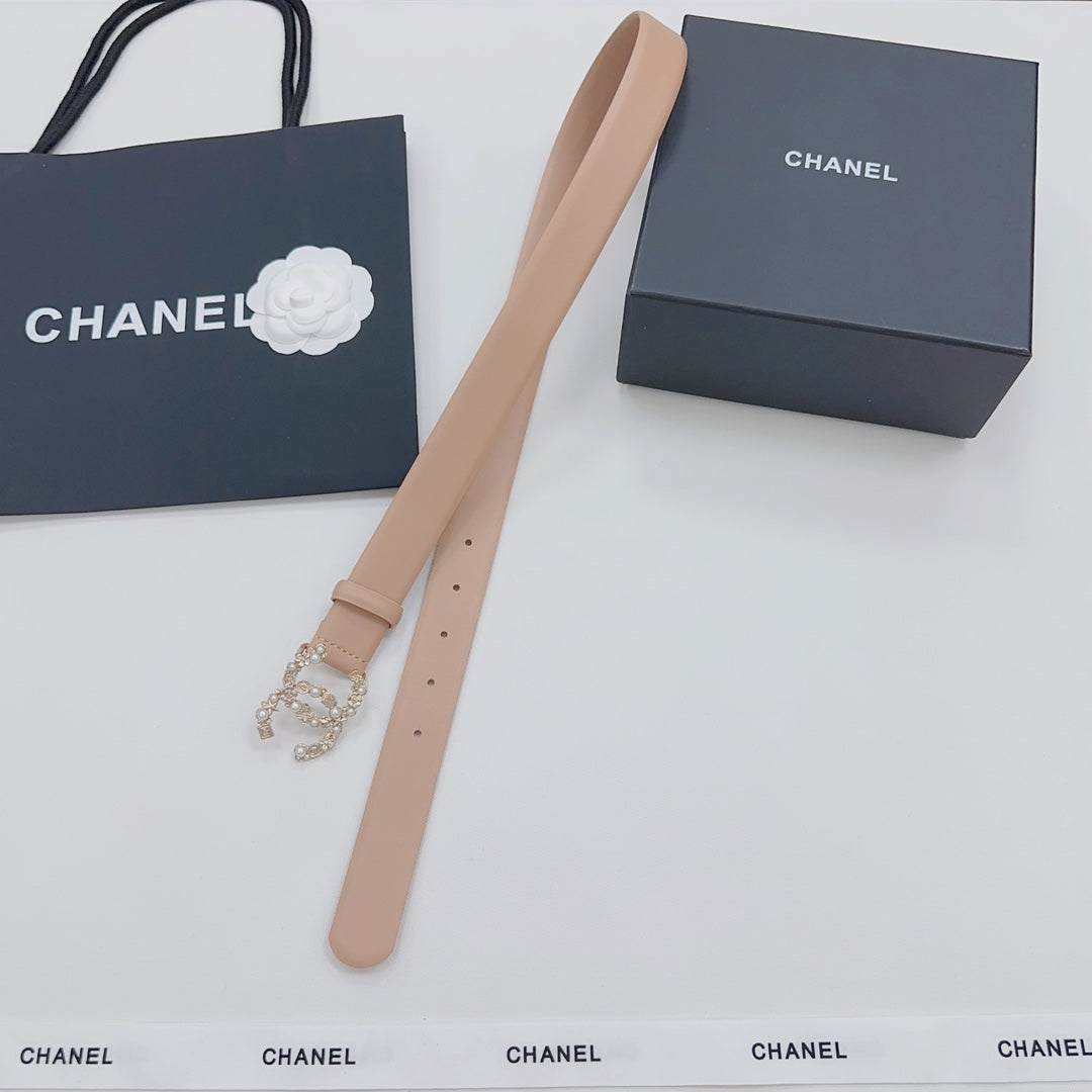 Beige Chanel belt with jeweled buckle, laid out with long strap ends