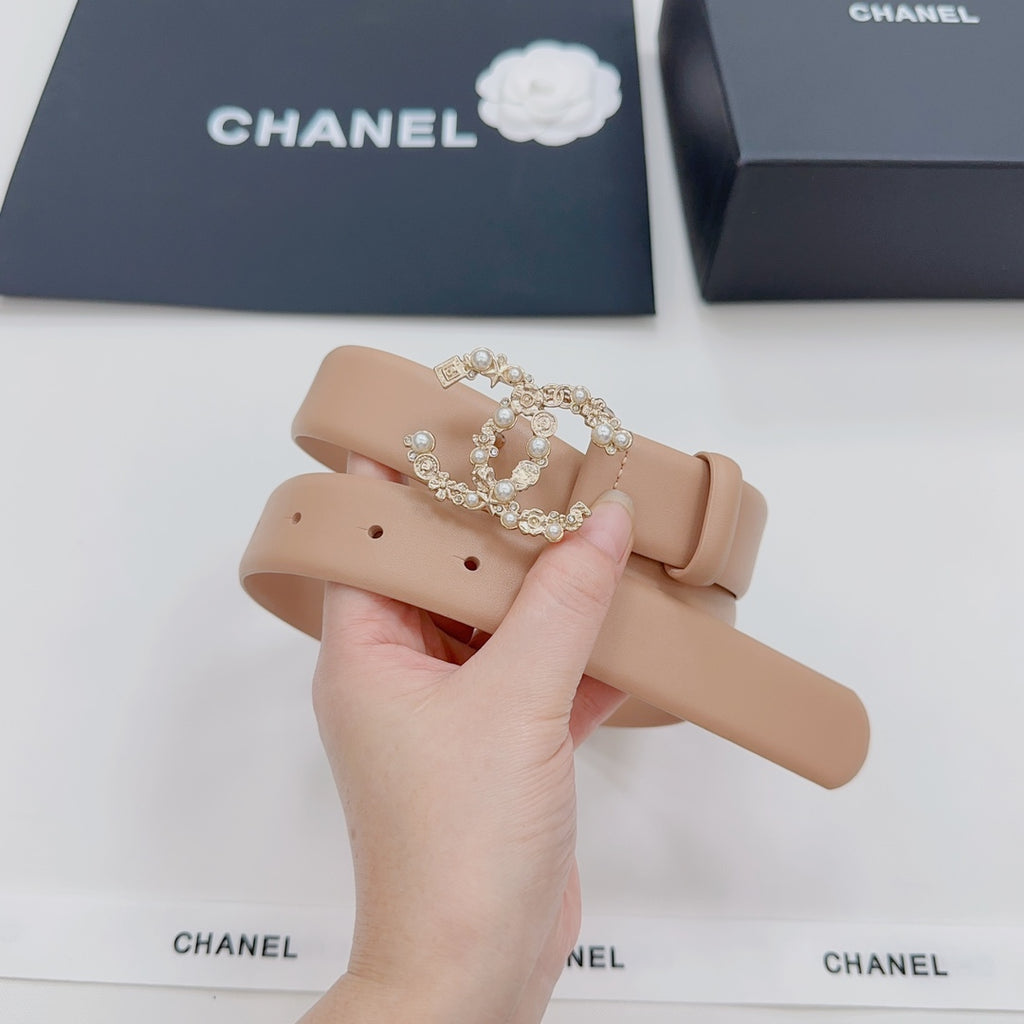 Beige Chanel belt with jeweled buckle and punched strap holes, held up