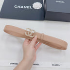 Beige Chanel belt with embellished logo buckle, held in hand