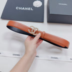 Orange leather belt with silver-tone embellished buckle, held in hand.