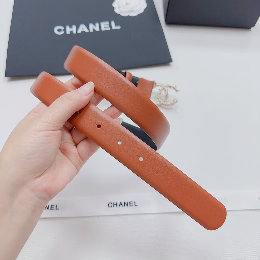 Orange leather belt shown folded with silver-tone buckle detail.
