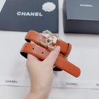 Orange leather belt with rhinestone-style CC buckle, held up for view.