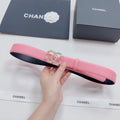 Pink leather belt with gold-tone crown buckle and black underside