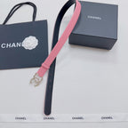 Pink leather belt with gold-tone crown emblem and black strap loop