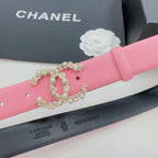 Pink leather belt with gold crown and pearl-like chain detail close-up