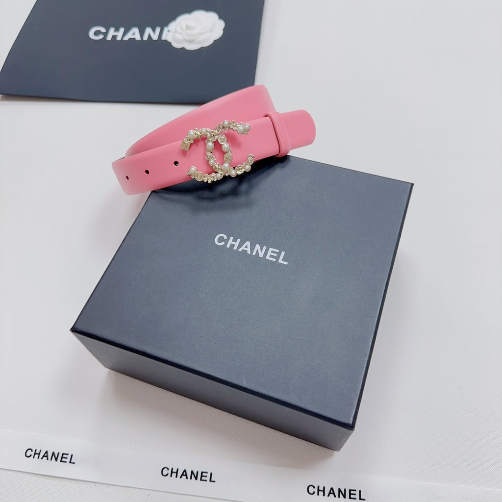 Pink leather belt with decorative crown buckle on adjustable strap