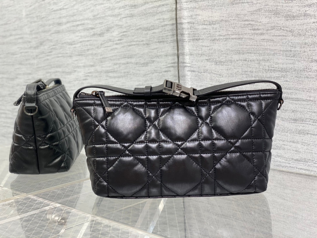 Quilted black Dior bag with top handle, adjustable strap, and clasp closure