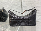 Quilted black Dior bag with zip-top opening and top handle detail