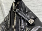 Black Dior bag close-up: gold-tone zipper and logo snap hardware