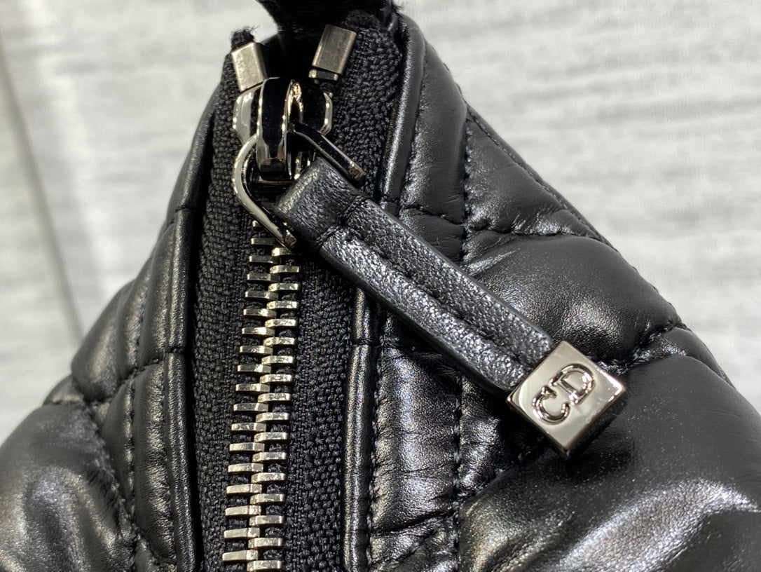 Black Dior bag close-up: gold-tone zipper and logo snap hardware